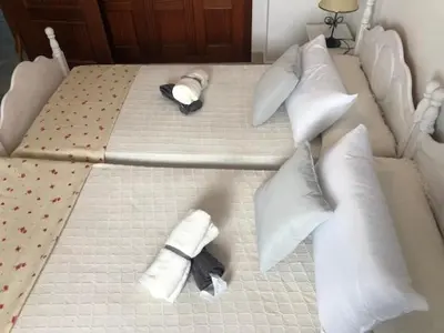 two beds with white pillows and a tie on them at ACOGEDOR APARTAMENTO EN SANLUCAR DE BARRAMEDA in Sanlúcar de Barrameda