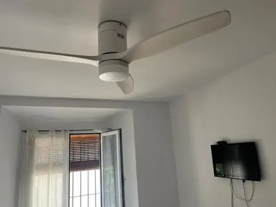 a ceiling fan in a room with a window at ACOGEDOR APARTAMENTO EN SANLUCAR DE BARRAMEDA in Sanlúcar de Barrameda