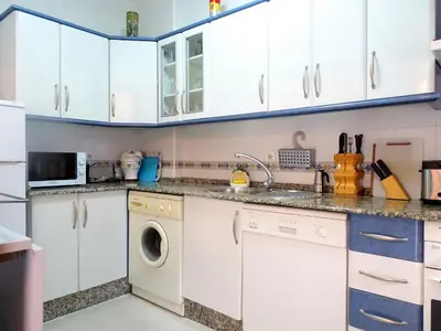a kitchen with white cabinets and a dishwasher at ACOGEDOR APARTAMENTO EN SANLUCAR DE BARRAMEDA in Sanlúcar de Barrameda