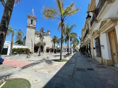 a street with a clock tower and a building at CASA RAUSER in Chipiona
