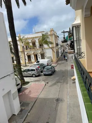 a city street with cars parked in front of buildings at CASA RAUSER in Chipiona