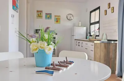 a kitchen with a table with a vase of flowers at Chalet Isla Papua in Chiclana de la Frontera