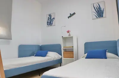 a bedroom with a bed with a large headboard at Chalet Isla Papua in Chiclana de la Frontera