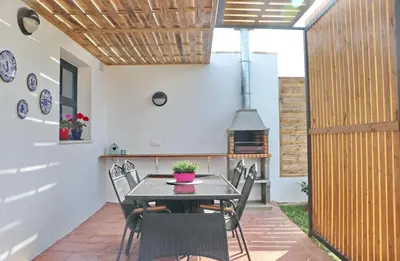 a kitchen and dining room with a table and chairs at Chalet Isla Papua in Chiclana de la Frontera