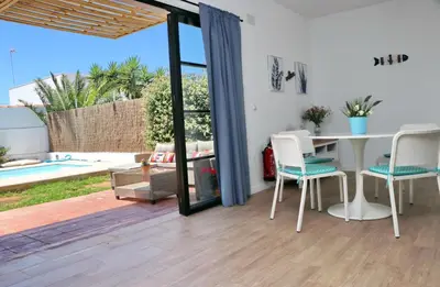 a kitchen and dining room with a table and chairs at Chalet Isla Papua in Chiclana de la Frontera