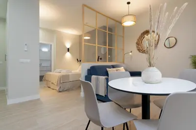 a living room with a table and a couch at Suit 42 Playa y Ascensor Grupo AC Gestion in Cádiz