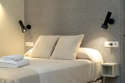 a bedroom with a white bed with two pillows at Suit 42 Playa y Ascensor Grupo AC Gestion in Cádiz