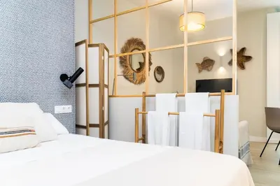 a bedroom with a white bed and towels at Suit 42 Playa y Ascensor Grupo AC Gestion in Cádiz