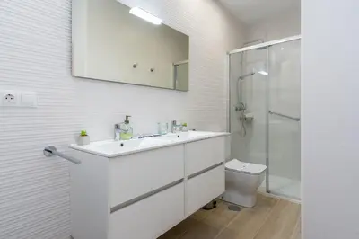 a white bathroom with a sink and a toilet at Suit 42 Playa y Ascensor Grupo AC Gestion in Cádiz