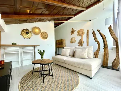 a living room with a white couch and a table at VILLA PIMIENTA, Chalet de lujo a 100 metros del mar in Chiclana de la Frontera