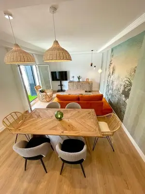 a living room with a table and chairs and a couch at VILLA PIMIENTA, Chalet de lujo a 100 metros del mar in Chiclana de la Frontera
