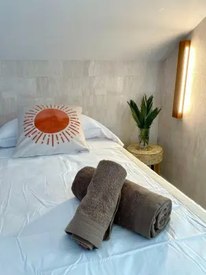 a bed with two towels and a pillow on it at VILLA PIMIENTA, Chalet de lujo a 100 metros del mar in Chiclana de la Frontera