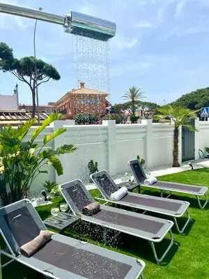 a group of lawn chairs sitting on the grass at VILLA PIMIENTA, Chalet de lujo a 100 metros del mar in Chiclana de la Frontera