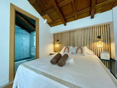 a bedroom with a large white bed with two pillows at VILLA PIMIENTA, Chalet de lujo a 100 metros del mar in Chiclana de la Frontera