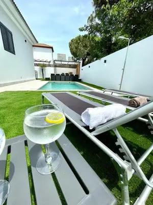 a table with a margarita sitting on top of a table at VILLA PIMIENTA, Chalet de lujo a 100 metros del mar in Chiclana de la Frontera