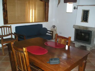 a living room with a wooden table and a fireplace at El Olivar de Roche Viejo in Conil de la Frontera