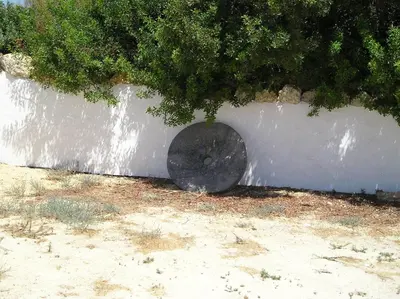 a white wall with a black circle on it at El Olivar de Roche Viejo in Conil de la Frontera