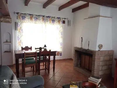 a living room with a table and a fireplace at El Olivar de Roche Viejo in Conil de la Frontera