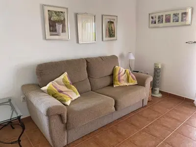 a couch in a living room with two pillows on it at Ático Amaranta in Chiclana de la Frontera