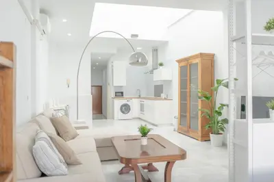 a white living room with a white couch and a table at LOFT SÚPER LUMINOSO EN EL CENTRO DEL PUERTO DE SANTA MARÍA. in El Puerto de Santa María