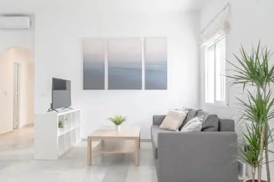 a living room with a gray couch and a tv at Apartamento completamente nuevo en pleno centro del Puerto in El Puerto de Santa María