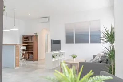 a white living room with a couch and a table at Apartamento completamente nuevo en pleno centro del Puerto in El Puerto de Santa María