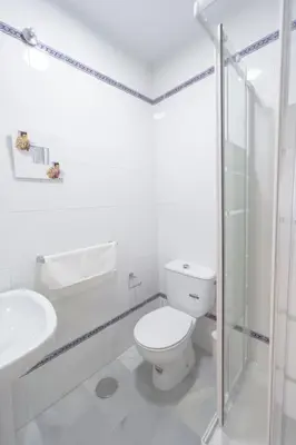 a white bathroom with a toilet and a sink at Apartamento completamente nuevo en pleno centro del Puerto in El Puerto de Santa María
