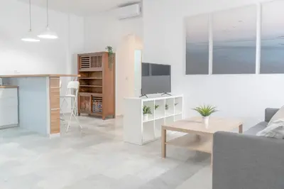 a living room with a couch and a tv and a table at Apartamento completamente nuevo en pleno centro del Puerto in El Puerto de Santa María