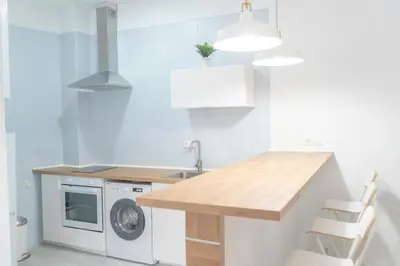 a kitchen with a table and a washing machine at Apartamento completamente nuevo en pleno centro del Puerto in El Puerto de Santa María