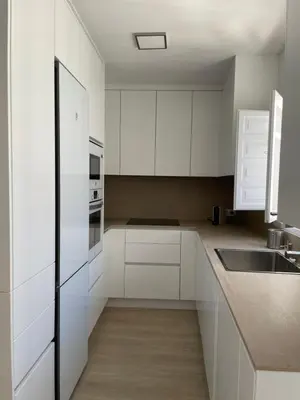 a white kitchen with white cabinets and a sink at Luz de la Caleta in Cádiz
