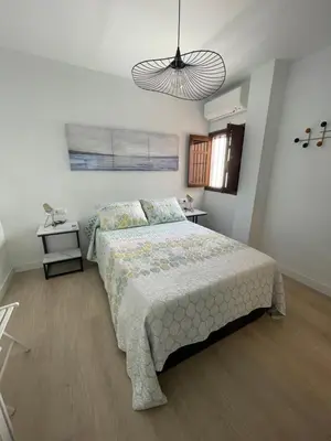 a bedroom with a bed and a pendant light at Luz de la Caleta in Cádiz