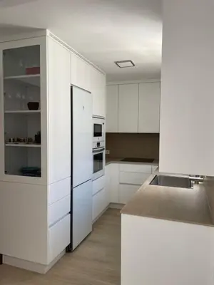 a kitchen with white cabinets and a black refrigerator at Luz de la Caleta in Cádiz