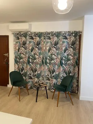 a room with two chairs and a wall with a wallpaper at Luz de la Caleta in Cádiz