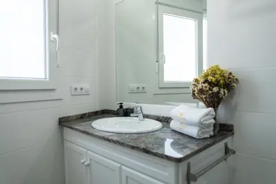 a white bathroom with a sink and a mirror at Prim 14 by 7Escalones in Rota