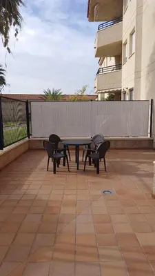 a picnic table and chairs on a patio with a building at Aires de Bajo de Guía, Apartamentos Living Sur in Sanlúcar de Barrameda