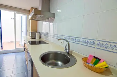 a kitchen with a sink and a basket on the counter at Aires de Bajo de Guía, Apartamentos Living Sur in Sanlúcar de Barrameda