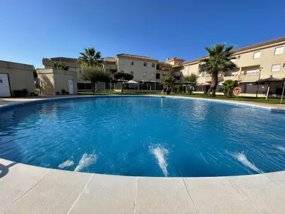 a large swimming pool in the middle of a building at Aires de Bajo de Guía, Apartamentos Living Sur in Sanlúcar de Barrameda