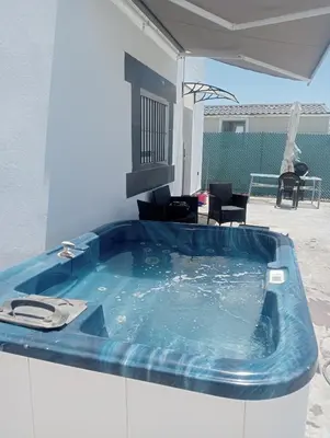 a jacuzzi tub in the middle of a patio at White relax house for 6 - Pool & Spa privé in Chiclana de la Frontera