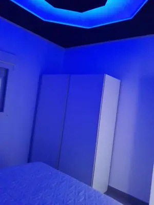 a bedroom with a bed with blue lights on it at White relax house for 6 - Pool & Spa privé in Chiclana de la Frontera