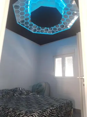 a room with a bed and a blue light on the ceiling at White relax house for 6 - Pool & Spa privé in Chiclana de la Frontera