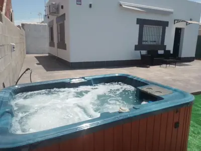 a jacuzzi tub with water in a yard at White relax house for 6 - Pool & Spa privé in Chiclana de la Frontera