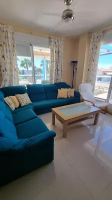 a living room with a blue couch and a coffee table at Ático en Costa Ballena con Barbacoa, Aire Acondicionado y WIFI in Costa Ballena