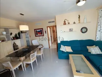 a living room with a blue couch and a table at Ático en Costa Ballena con Barbacoa, Aire Acondicionado y WIFI in Costa Ballena
