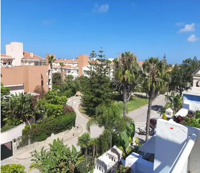 a view of a street with palm trees and buildings at Ático en Costa Ballena con Barbacoa, Aire Acondicionado y WIFI in Costa Ballena