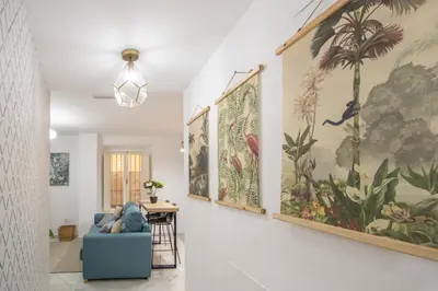 a living room with large paintings on the walls at Apartamento La Magnolia de Cádiz in Cádiz