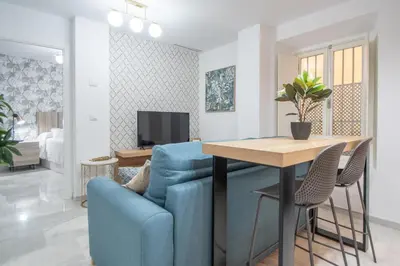 a living room with a blue couch and a table at Apartamento La Magnolia de Cádiz in Cádiz