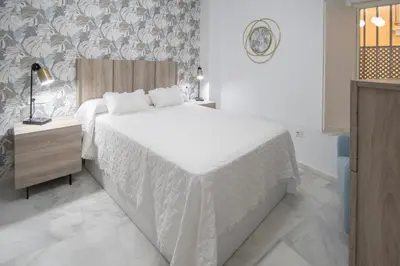 a bedroom with a bed with a white bedspread at Apartamento La Magnolia de Cádiz in Cádiz