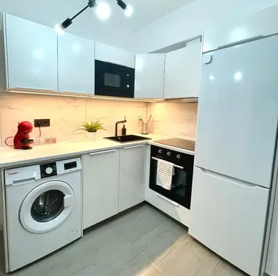 a kitchen with a washing machine and a refrigerator at Carmen viejo 12 in Sanlúcar de Barrameda