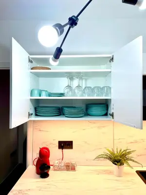 a kitchen with a white cabinet with dishes in it at Carmen viejo 12 in Sanlúcar de Barrameda