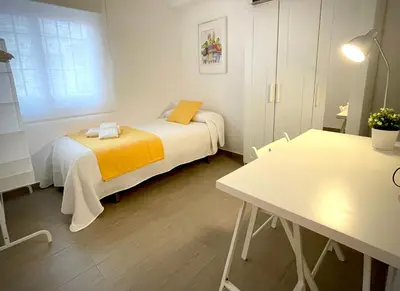 a small room with two beds and a table at Carmen viejo 12 in Sanlúcar de Barrameda